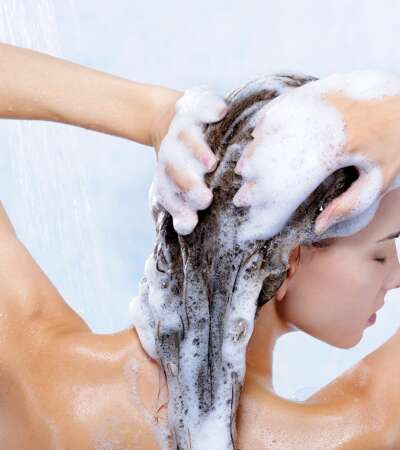 kobieta myje włosy szamponem